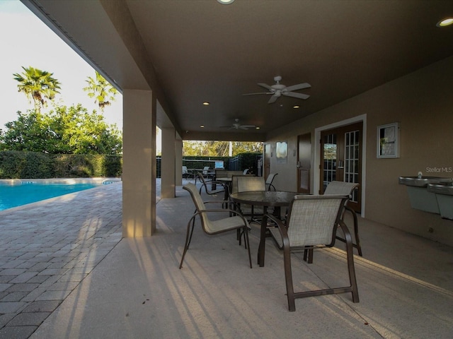 view of patio featuring a ceiling fan, a fenced in pool, and outdoor dining area