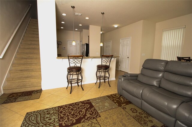 living room with light tile patterned flooring, recessed lighting, visible vents, baseboards, and stairs