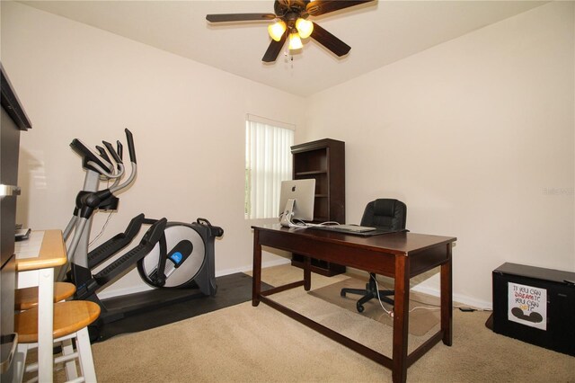 carpeted office with ceiling fan and baseboards