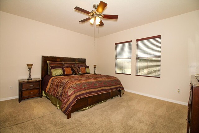 bedroom with light carpet, ceiling fan, and baseboards