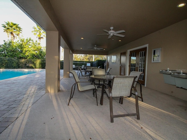 view of patio with a fenced in pool, a ceiling fan, and outdoor dining space