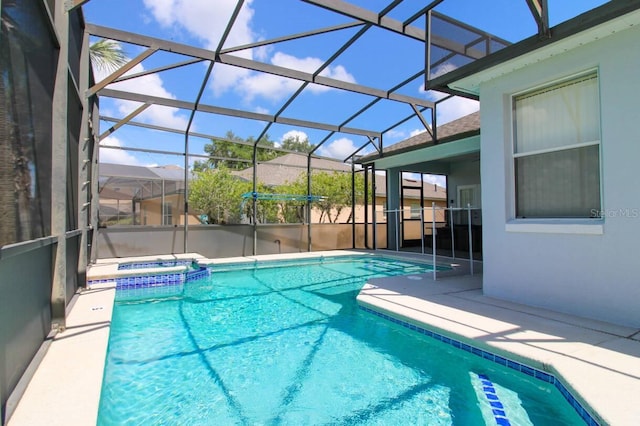 view of pool featuring a lanai, a patio, and an in ground hot tub