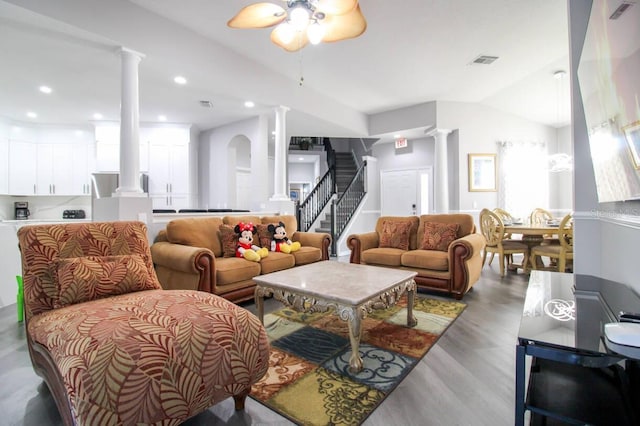 living room featuring ceiling fan, wood-type flooring, vaulted ceiling, and ornate columns