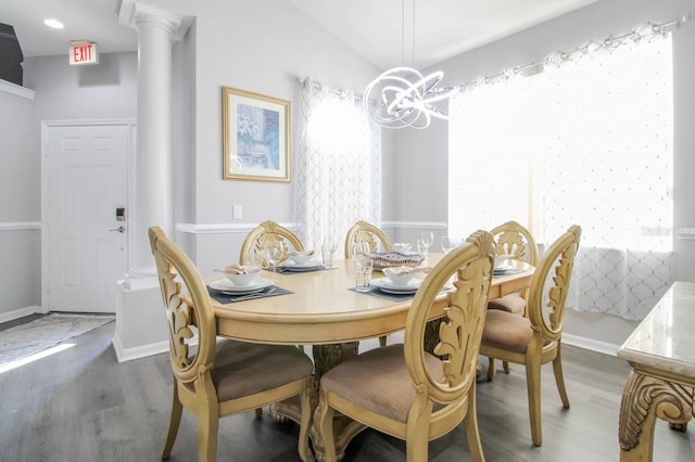 dining room with ornate columns, vaulted ceiling, dark hardwood / wood-style floors, and a notable chandelier