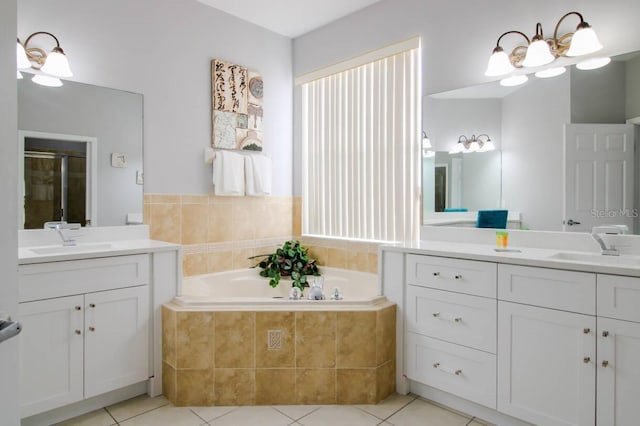 bathroom with tiled tub, vanity, and tile patterned floors