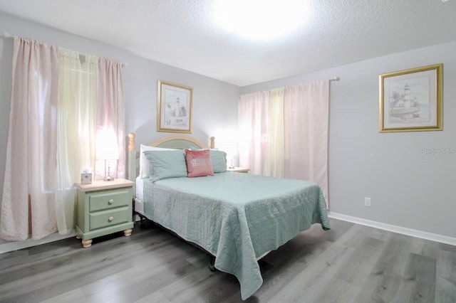 bedroom with light hardwood / wood-style floors and a textured ceiling