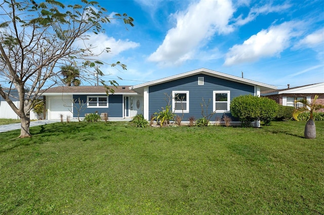 rear view of property featuring a garage and a yard