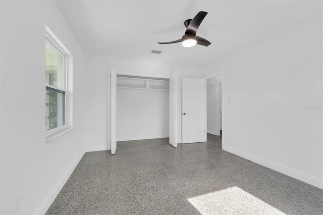 unfurnished bedroom with ceiling fan and a closet