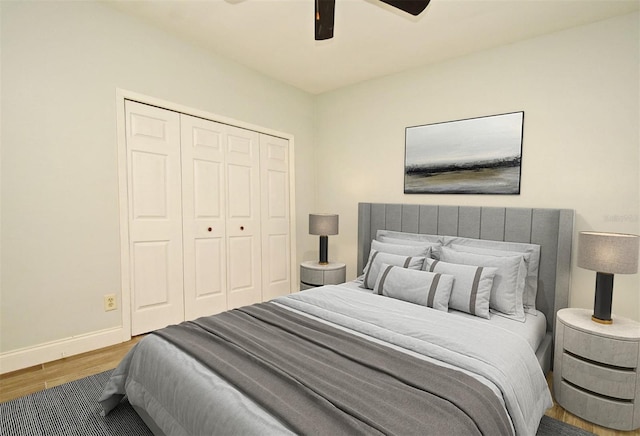 bedroom featuring wood-type flooring, ceiling fan, and a closet