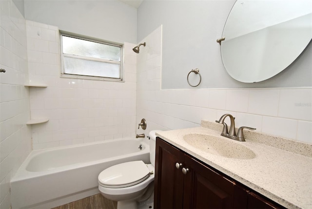 full bathroom featuring tile walls, backsplash, tiled shower / bath combo, vanity, and toilet