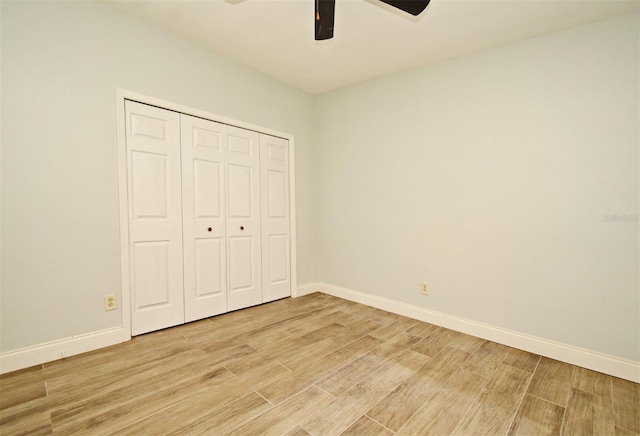 unfurnished bedroom with ceiling fan and a closet