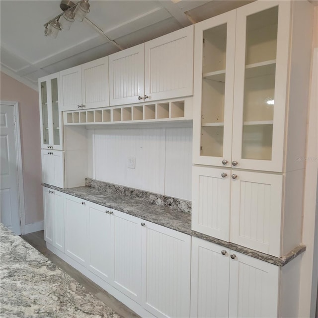 kitchen with white cabinetry and light stone counters