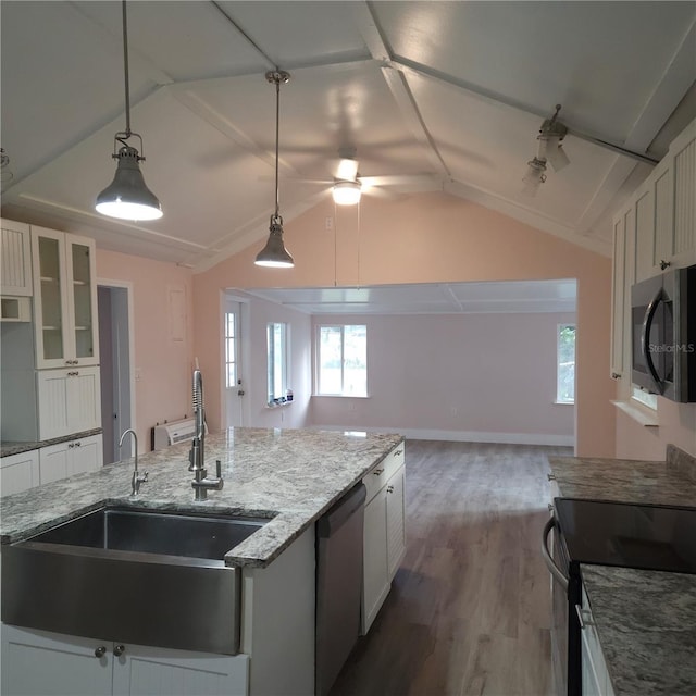 kitchen featuring pendant lighting, lofted ceiling, appliances with stainless steel finishes, and white cabinets