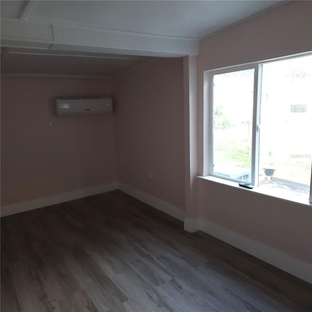 unfurnished room featuring a wall mounted AC, hardwood / wood-style floors, and a wealth of natural light