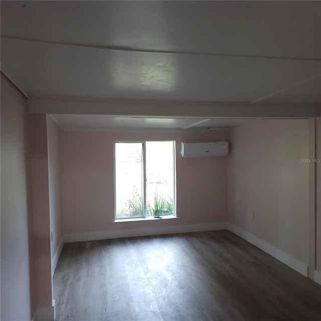 unfurnished room featuring hardwood / wood-style floors and a wall mounted AC