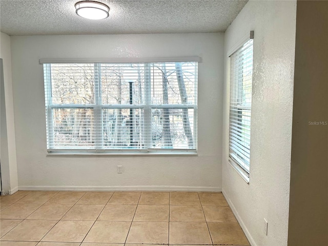 unfurnished room featuring light tile patterned floors and a textured ceiling