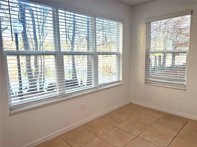 spare room with tile patterned flooring and a healthy amount of sunlight