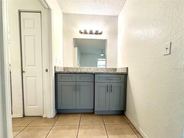 bathroom featuring vanity, tile patterned flooring, and a textured ceiling