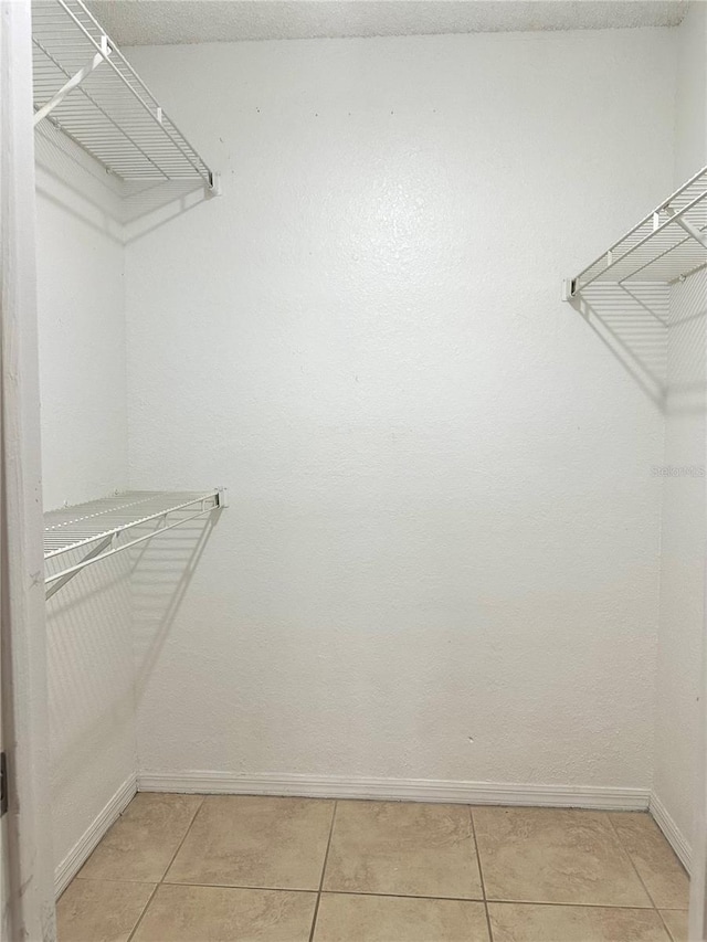 walk in closet with light tile patterned floors