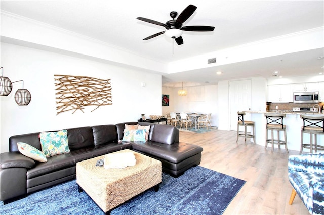 living room featuring crown molding, ceiling fan, and light hardwood / wood-style floors