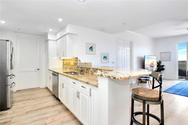 kitchen with stainless steel appliances, kitchen peninsula, sink, and a breakfast bar area