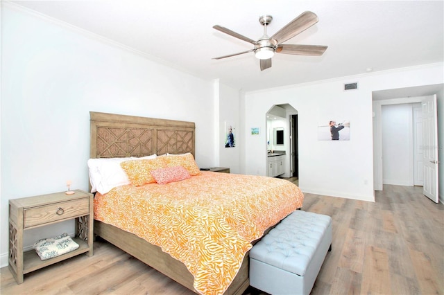 bedroom featuring hardwood / wood-style flooring, ceiling fan, ornamental molding, and ensuite bath