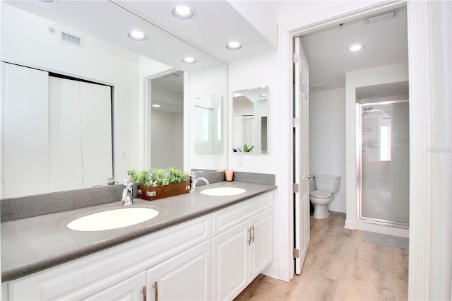 bathroom featuring vanity, hardwood / wood-style flooring, toilet, and walk in shower