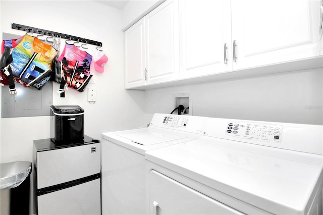 laundry room with separate washer and dryer and cabinets