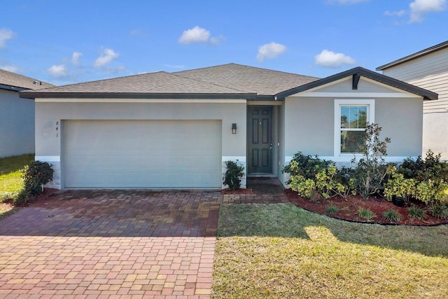 ranch-style house with a garage and a front yard