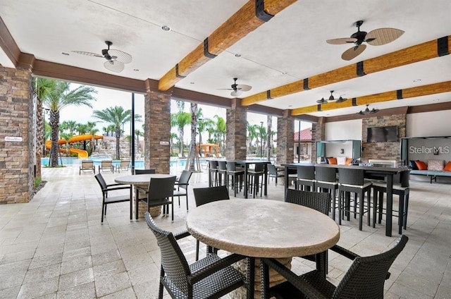 view of patio / terrace featuring exterior bar, a community pool, and ceiling fan