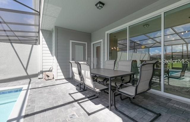 view of patio featuring glass enclosure