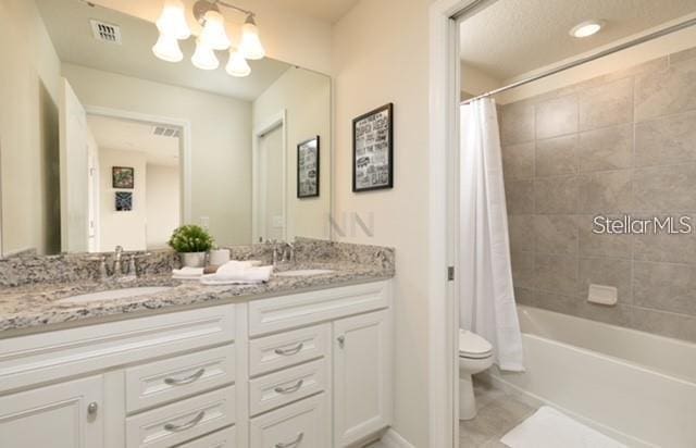 full bathroom featuring shower / tub combo, an inviting chandelier, vanity, tile patterned floors, and toilet