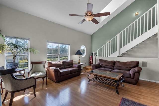 living room featuring hardwood / wood-style floors, high vaulted ceiling, and ceiling fan