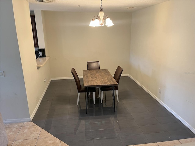 tiled dining room featuring an inviting chandelier