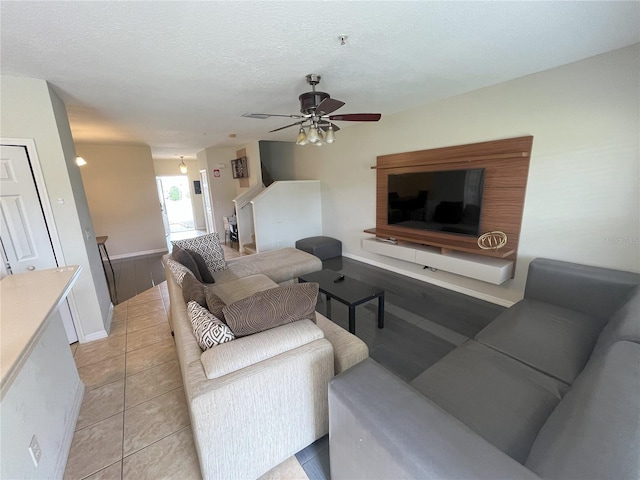 tiled living room featuring ceiling fan and a textured ceiling