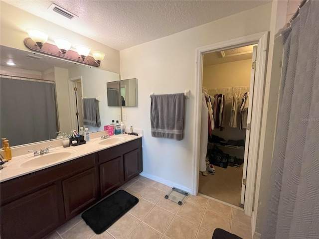 bathroom with vanity, tile patterned flooring, and a textured ceiling