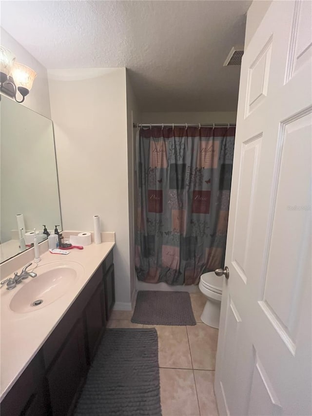 full bathroom with shower / tub combo, vanity, a textured ceiling, tile patterned floors, and toilet