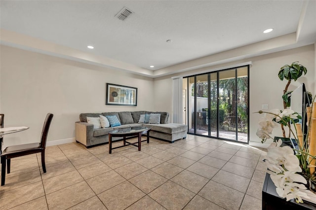 living room featuring light tile patterned floors and a tray ceiling