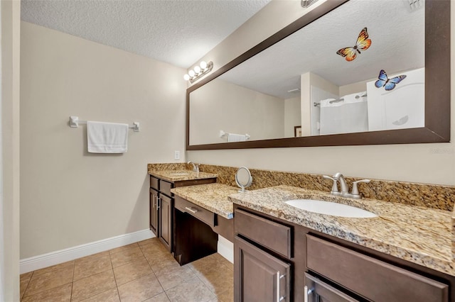 bathroom with a shower, tile patterned floors, a textured ceiling, and vanity