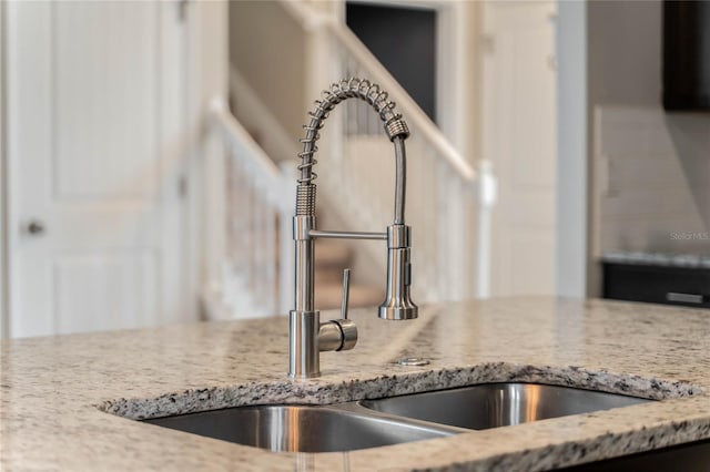 details featuring light stone countertops and sink