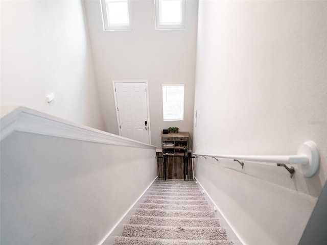 stairs featuring a high ceiling and a wealth of natural light