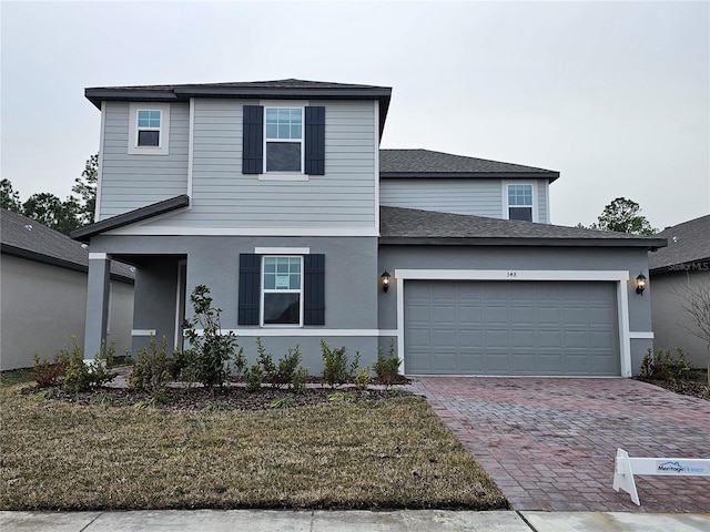 front facade with a garage and a front lawn