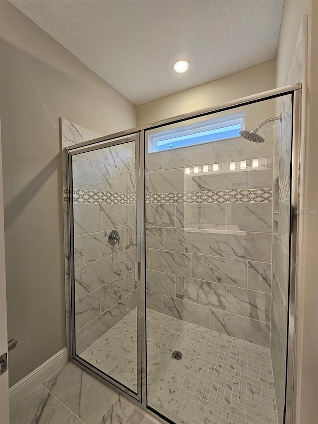 bathroom with a shower with door and a textured ceiling