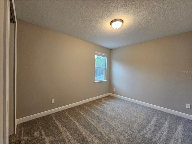 unfurnished room with carpet and a textured ceiling