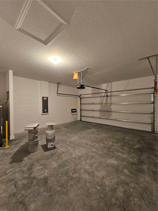 garage with a garage door opener and electric panel