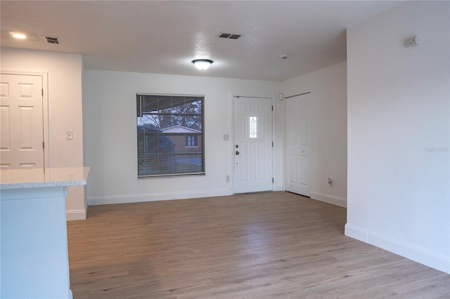 entrance foyer featuring baseboards, visible vents, and light wood-type flooring