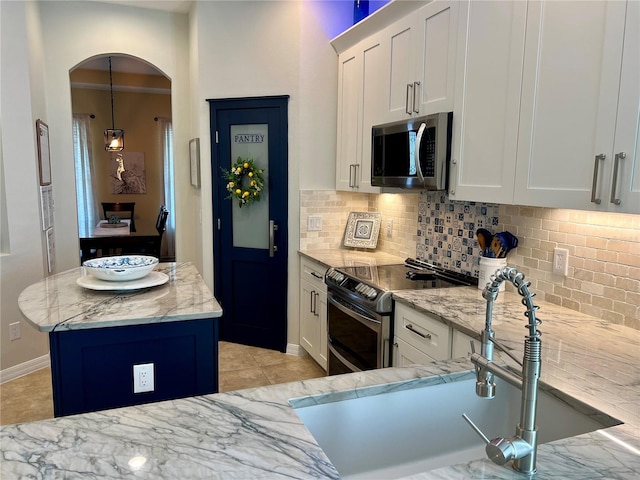 kitchen with sink, white cabinetry, light stone counters, a center island, and stainless steel appliances