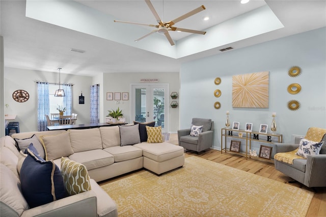 living room with ceiling fan, a healthy amount of sunlight, light hardwood / wood-style floors, and french doors