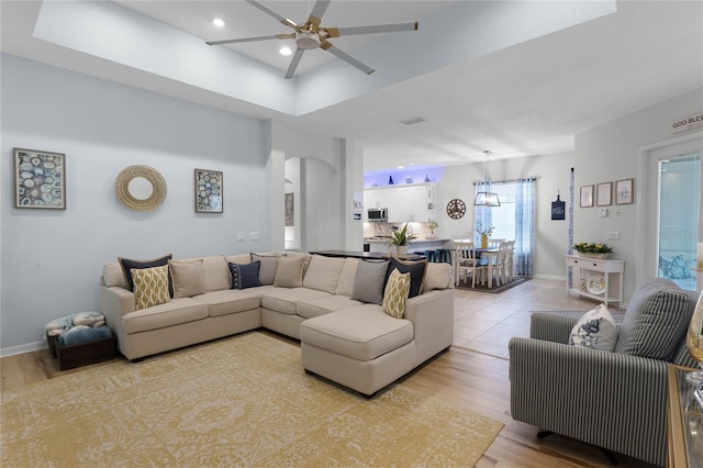 living room with light wood-type flooring and ceiling fan