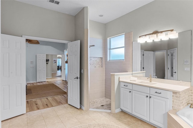 bathroom featuring tile patterned floors, shower with separate bathtub, and vanity